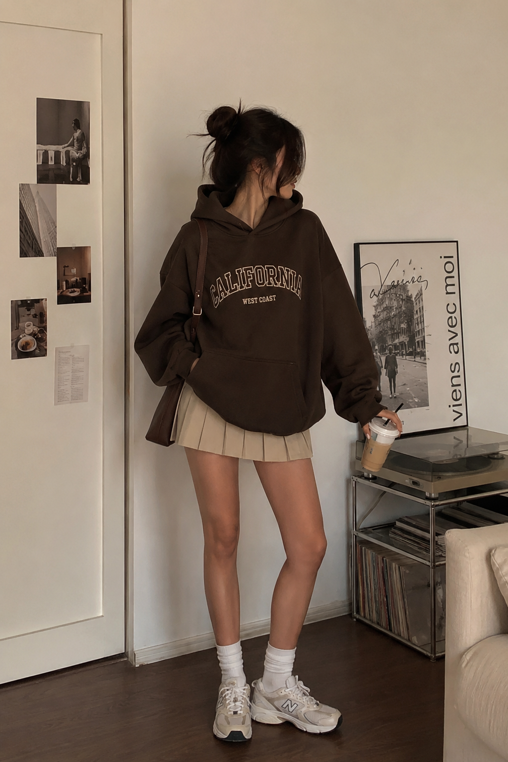 Pull marron oversize avec mini jupe en dentelle et bottines.