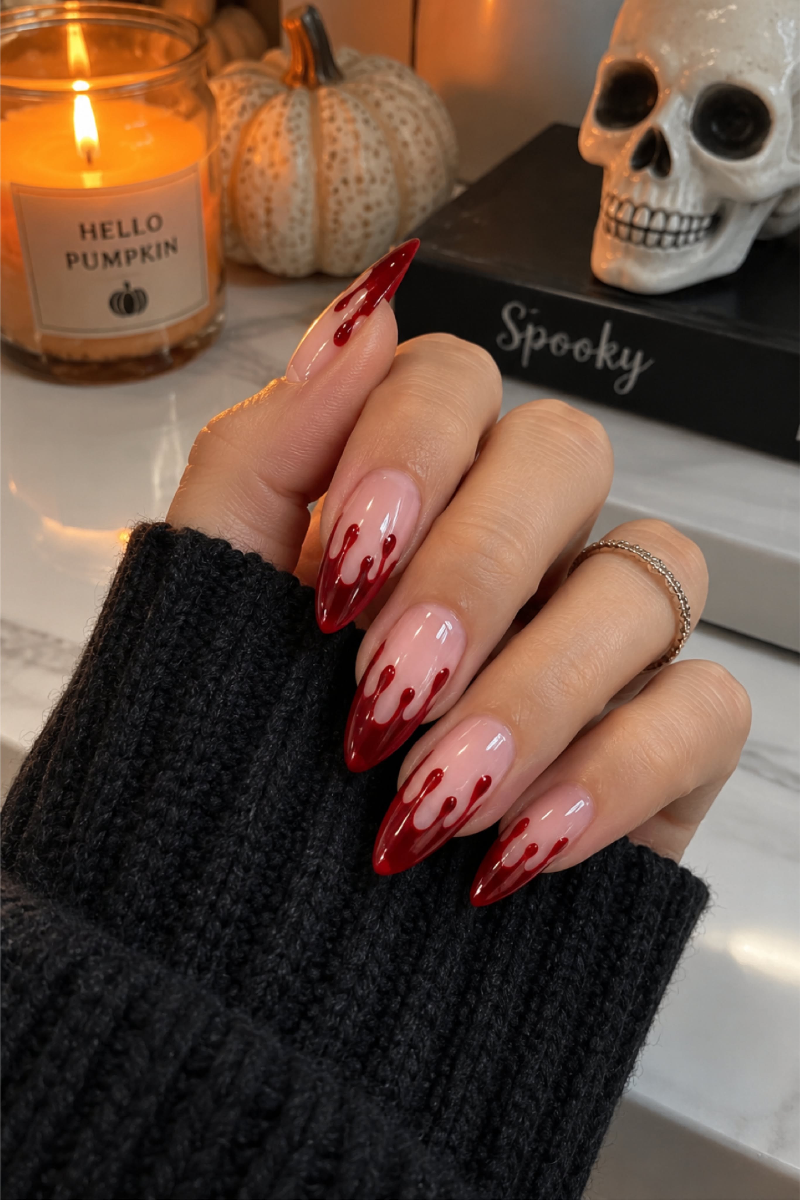 Ongles longs avec motif rouge effet sang sur fond naturel.