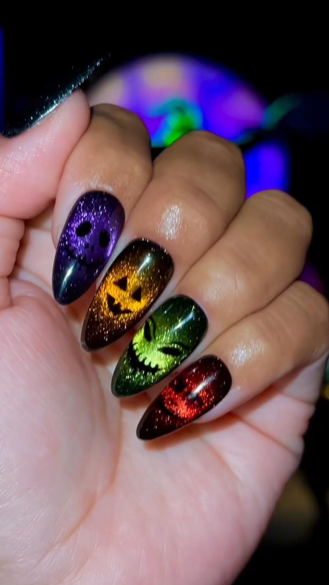 Ongles longs en forme amande avec motifs Halloween colorés et brillants.