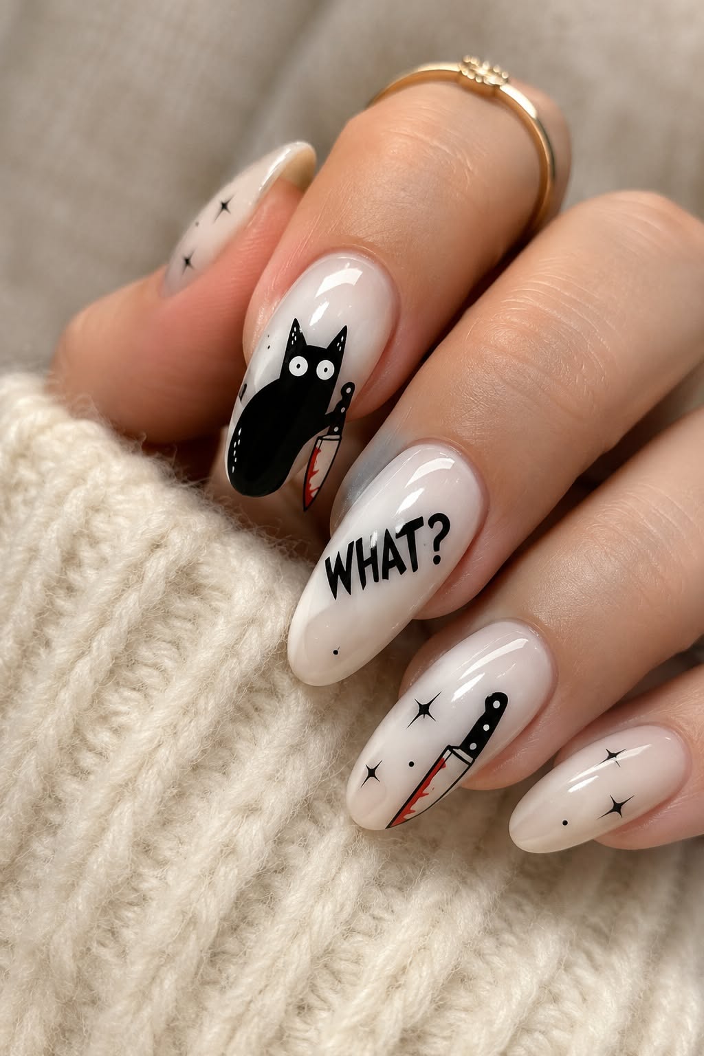 Nails painted with a black cat, bloody knife, and the word WHAT?