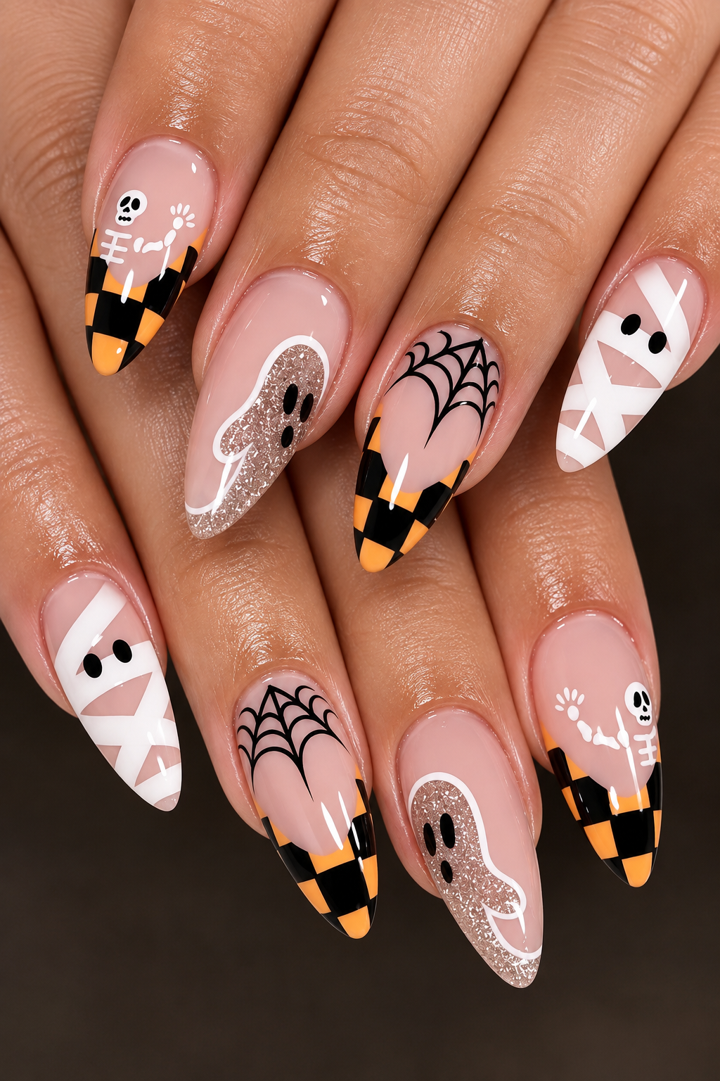 Nails decorated with Halloween-themed designs including skeletons, ghosts, spider webs, and mummies.
