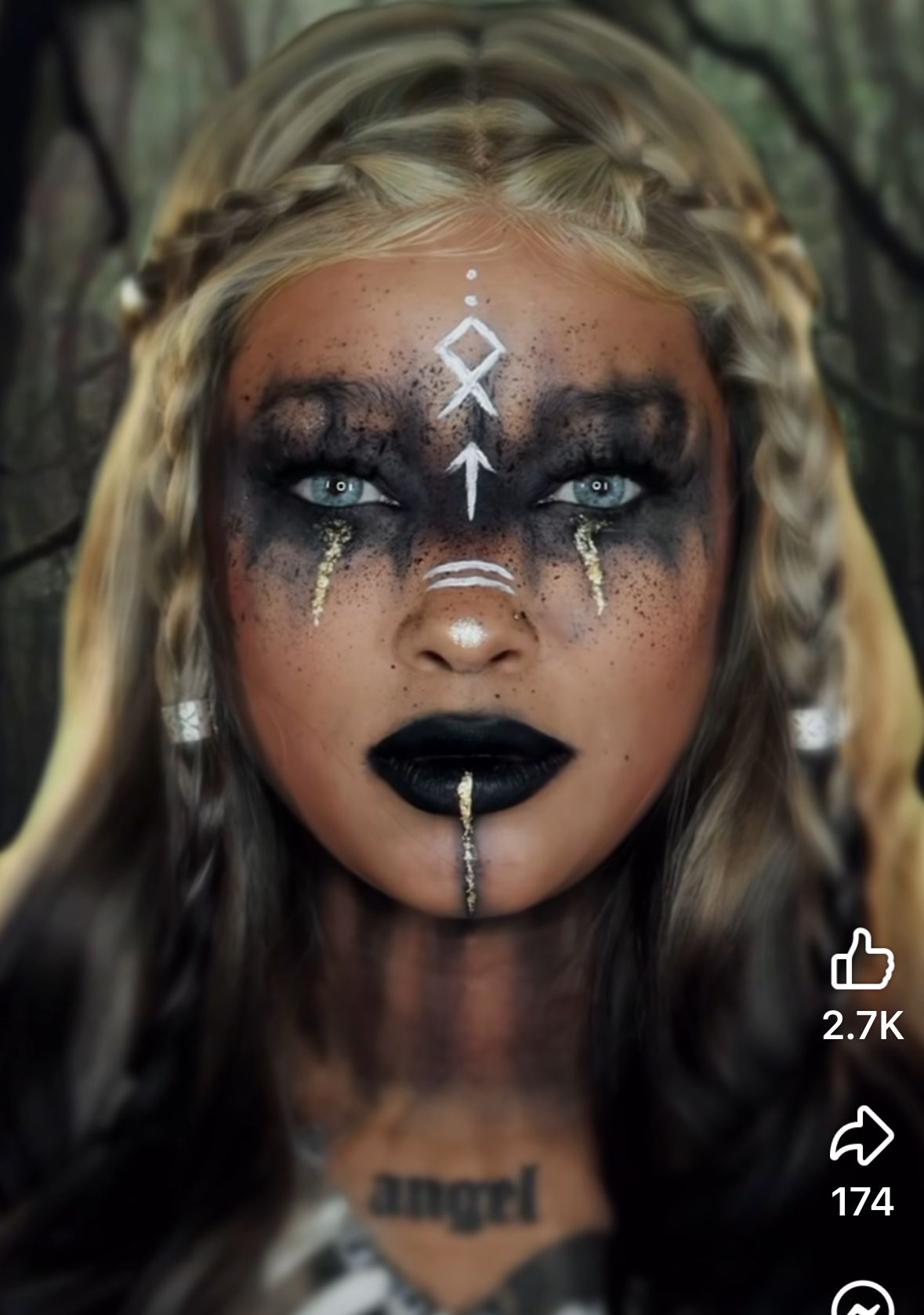 Visage maquillé avec noir, blanc et doré pour un look sorcière chic.